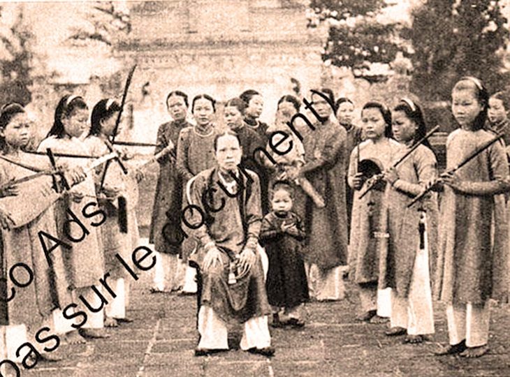 Bí ẩn mỹ nhân nội cung vua Khải Định kỳ 4: Nỗi niềm cung oán của tứ giai Du Tần- Ảnh 1. Bà Du Tần Võ Thị Dung, người đeo kiềng đứng sau vai phải của Khôn Nghi Xương Đức Thái hoàng thái hậu (bà nội vua Bảo Đại, còn gọi là đức Tiên Cung, tục danh Dương Thị Thục, ngồi). Ảnh đăng kèm bài viết về vua Bảo Đại chuẩn bị chuyến Bắc hành, đăng trong Tập san Le Journal Hebdomadaire, 1933. Chuyến đi này có bà Tân Du theo đoàn, sau đó bà xin rời hoàng cung - Ảnh tư liệu