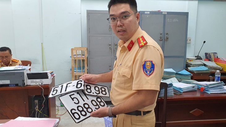 'Biển số định danh cho xe tải không thể gắn vào ô tô con' - Ảnh 1. Lực lượng cảnh sát giao thông thu hồi biển số xe sau khi một người chủ bán xe - Ảnh: MINH HÒA